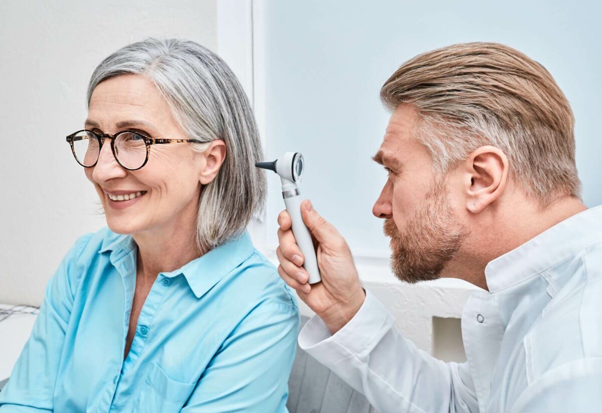 Otolaryngologist doctor checking ear of patient
